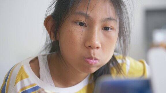 亚洲女孩在家窗前吃玉米蛋黄酱包(玉米面包)慢镜头