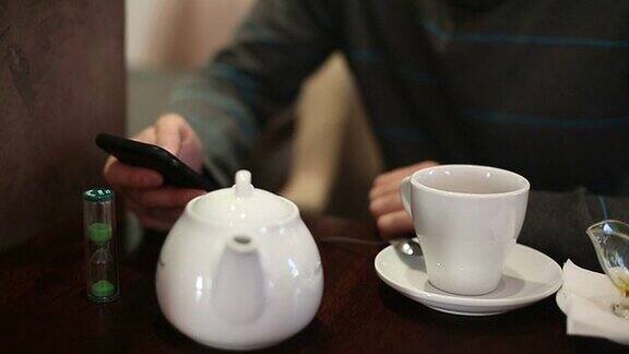 一名男子在咖啡馆用智能手机发短信