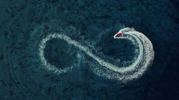 慢动作航拍的一个快速快艇与红色的屋顶使一个无限的形状在清澈的绿松石魔法海洋爱的象征