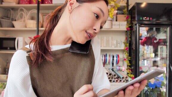 微笑的亚洲职业女性在友好地打电话使用平板电脑也可能是在与业务联系人或客户交谈技术、生活方式、创业、视觉、创新机会小型企业领导关系成功