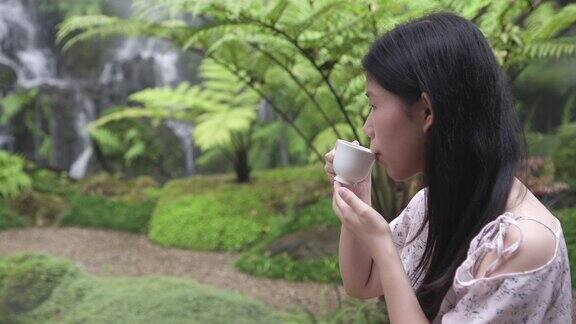 亚洲女孩在花园喝茶与复印空间