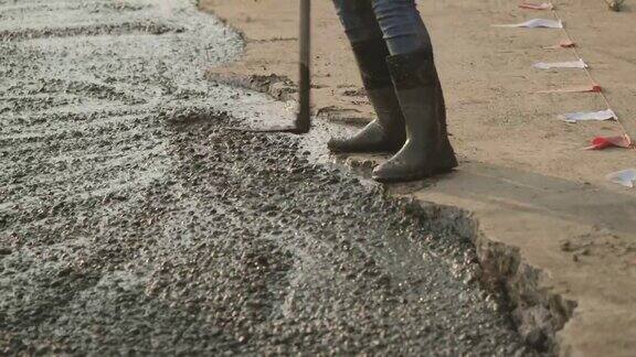 手工工人用泥铲把水泥路面擦平