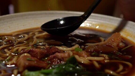 女人用棍子吃牛肉面的慢动作中国餐馆