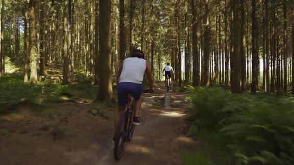 山地自行车手在森林里的土路上骑车