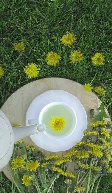 蒲公英茶杯在绿色的自然背景草药茶制成的黄色蒲公英花在春天花园垂直视频
