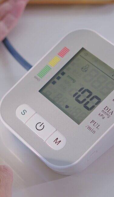 老奶奶手持医疗器械在家检查血压和心率