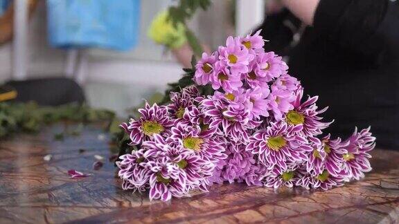 一个女人用紫色的菊花做花束