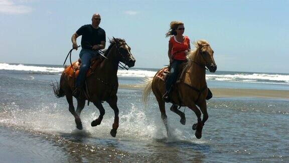 一对情侣在海滩上骑马慢镜头