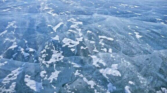 雪在冰面上飞舞雪花在贝加尔湖的冰面上飞舞冰非常美丽有独特的裂缝雪花闪耀着红光在日落时分高对比度