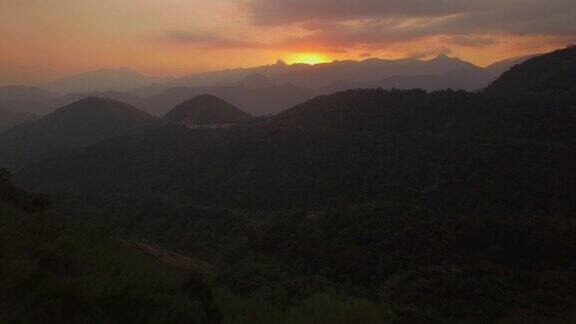 空中飞向日落穿过森林的山