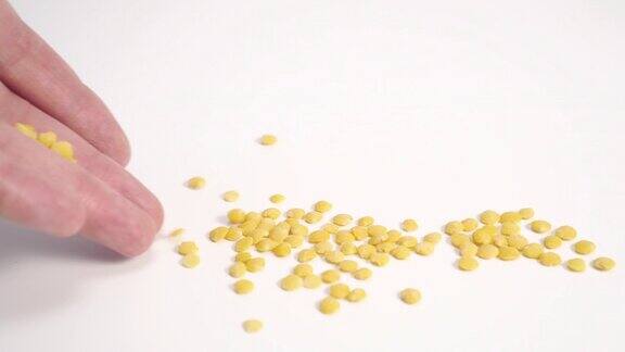 黄色剥皮扁豆近距离撒在白色的桌子上