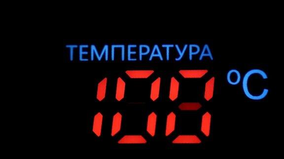 红色数字的数字温度计在黑色背景下显示摄氏温升铭文用俄语写“温度”