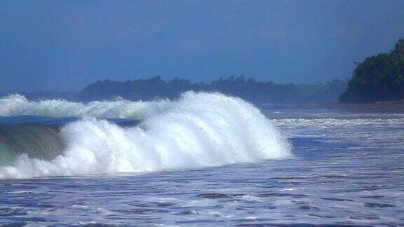 慢镜头:巨大的热带海浪拍打礁石滚向巴厘岛海岸