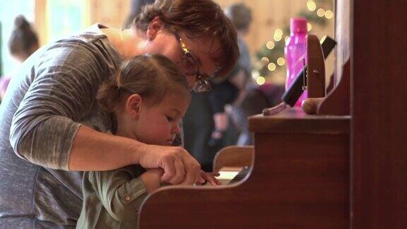圣诞节美国大家庭庆祝祖母和孙女弹钢琴