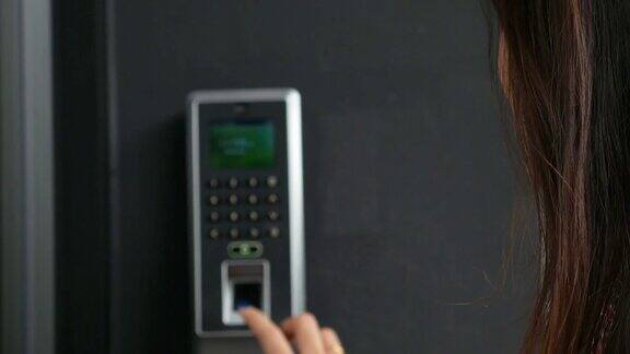 女人在电动门上扫描指纹按门铃