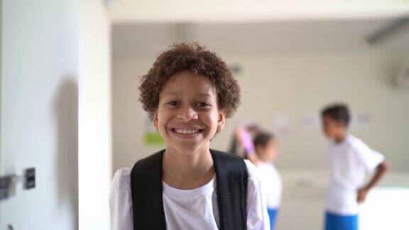 一个快乐的小学生在学校走廊里的肖像