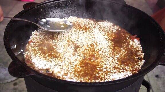 用漏勺把米饭撒在沸腾的乌兹别克肉饭上