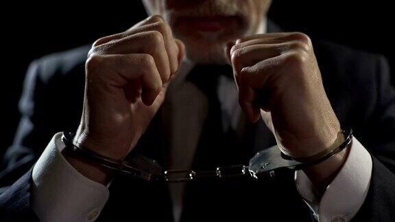愤怒的罪犯被戴上手铐监禁不公平的商人因犯罪而受到惩罚