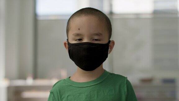 在一场全球大流行期间戴口罩的小男孩准备返回学校