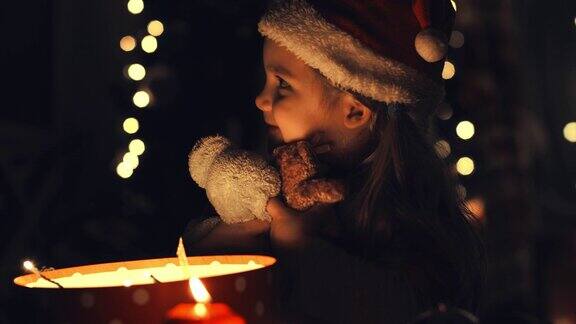 漂亮的小女孩抱着圣诞礼盒里的泰迪熊