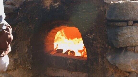 在传统窑炉中烧柴的场景