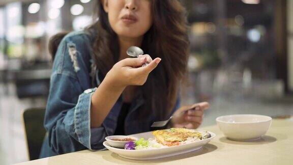 年轻的亚洲女人坐在自助餐厅吃饭美丽的亚洲女孩独自吃饭