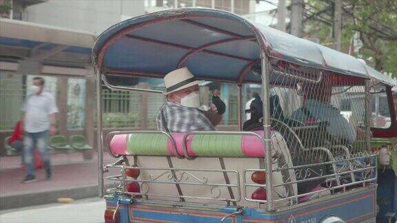 曼谷轮椅旅游地标概念亚洲男性游客乘坐传统的公共嘟嘟车