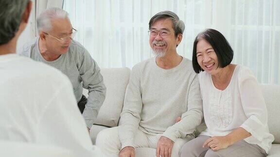 快乐情感老人们在客厅一起大笑一位老人在家里跟朋友讲有趣的故事