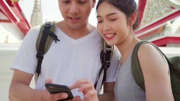 旅行者亚洲夫妇在曼谷的位置地图上的方向泰国夫妇使用手机在地图上寻找地标而花假期旅行生活方式夫妇旅游在城市