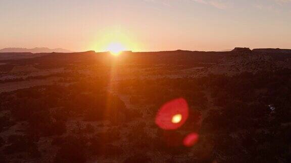 冉冉升起的无人机在沙漠上空拍摄太阳升起的画面