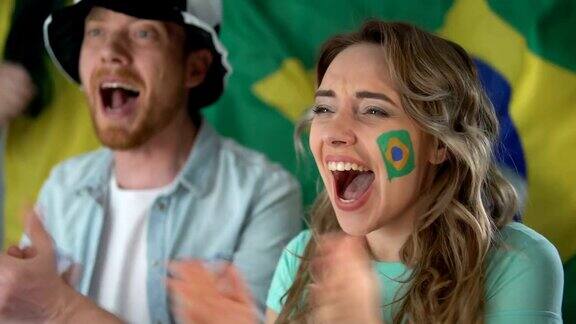 巴西球迷在电视上观看足球比赛庆祝球队胜利