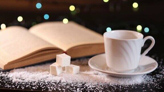 圣诞晚上用一个白色的杯子和碟子配上茶或咖啡白色的棉花糖