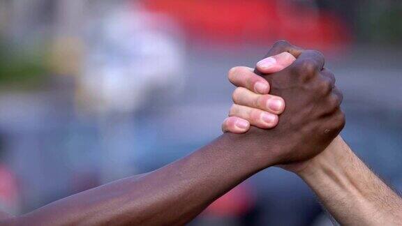 团结、平等、友爱一个白人和一个黑人握手致意