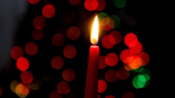 红烛在黑暗的背景圣诞蜡烛在散景灯的背景圣诞晚上新年圣诞节彩色圆圈散景特写