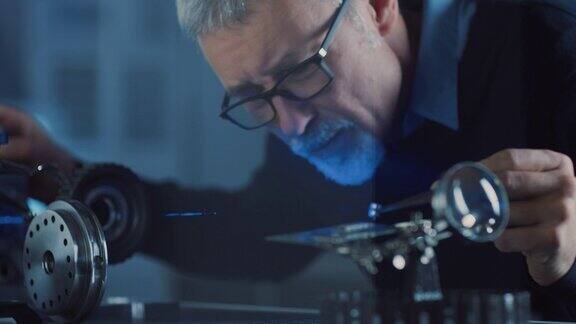 聚焦的中年工程师的特写肖像在高精密激光设备工作使用透镜和测试光学精度所要求的电子
