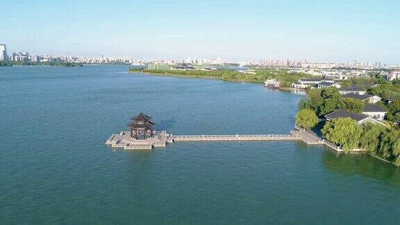 鸟瞰图上的传统中国古代亭在湖上日落在背景的城市风景