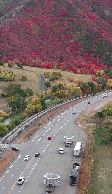 一架缓慢移动的无人机拍摄的6号高速公路蜿蜒穿过犹他州西班牙叉附近的山脉在一个秋天的下午颜色开始变化