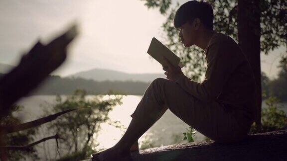 年轻人在湖边看书放松心情