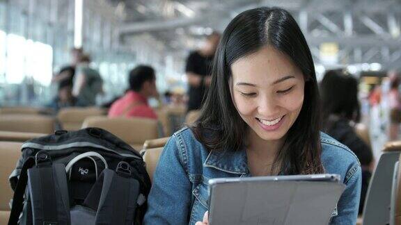 亚洲女性在机场使用平板电脑
