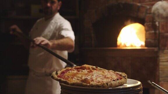 披萨师傅将新鲜出炉的带皮那不勒斯披萨放在盘子里