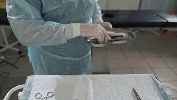 特写外科医生从手术台上拿起手臂上的医疗器械医生在医院带消毒工具手术前医疗设备的准备健康的理念诊所的设备