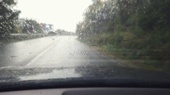 透过车窗看路有雨滴在雨中行驶