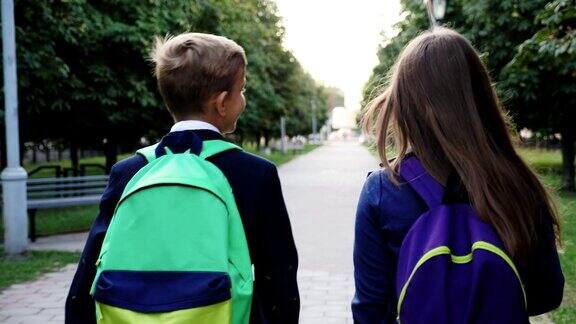 男孩和女孩带着书包走路