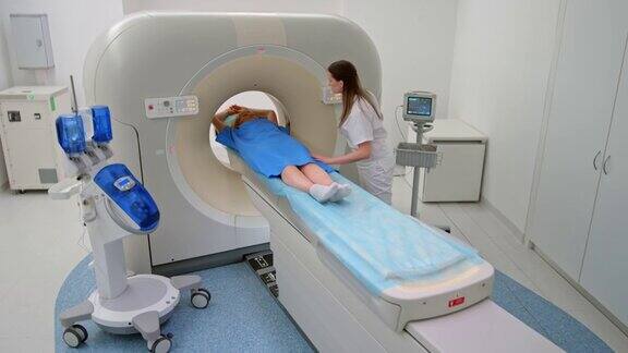 CS女核磁共振技术人员与女患者交谈同时将她推入核磁共振机器