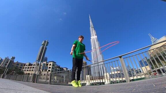 男子在迪拜的城市景观背景上跳绳慢动作