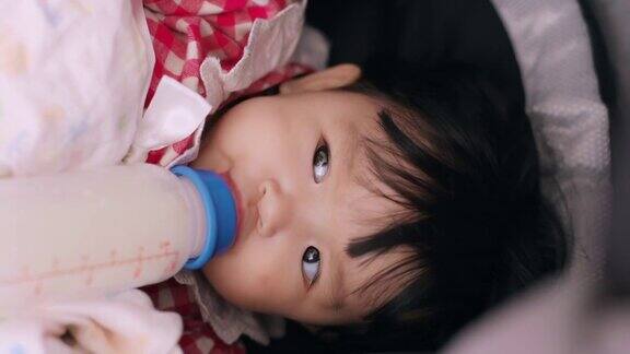 婴儿喝牛奶的垂直视频