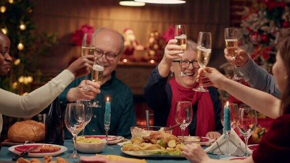 积极喜庆的人们在晚餐时碰杯庆祝圣诞节