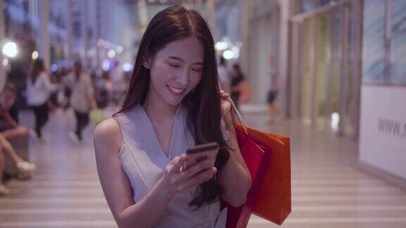 一名女子在购物中心使用智能手机