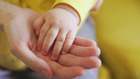 婴儿触摸妈妈的手的特写
