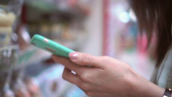 女人在超市使用智能手机特写